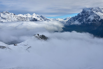 Fototapeta na wymiar Clouds in the mountain valley with peaks above. Jungfrau region in Switzerland.