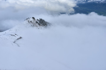 Clouds in the mountain valley with peaks above. Jungfrau region in Switzerland.