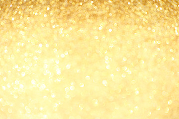 Golden sparkle glitters with bokeh effect and selectieve focus. Festive background with bright gold lights, champagne bubble. Christmas mood concept. Copy space, close up, texture, top view.