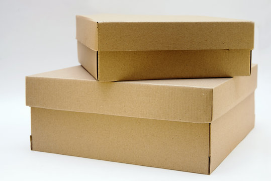 two cardboard boxes lie one on the other on a white background