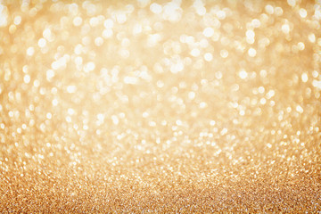 Golden sparkle glitters with bokeh effect and selectieve focus. Festive background with bright gold lights, champagne bubble. Christmas mood concept. Copy space, close up, texture, top view.