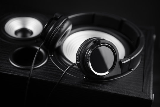 Photo of black headphones on music audio speaker. Close-up.