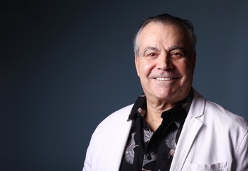 Beautiful older man in front of a colored background