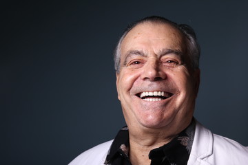 Beautiful older man in front of a colored background