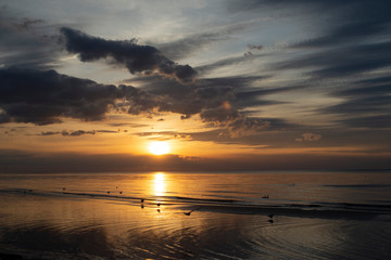 sea sunset on the beach, black clouds, orange sun