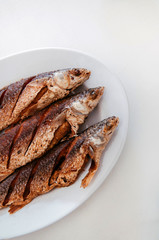 Thai style deep fried fishes on white plate, Top view