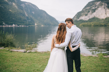 A wedding couple on the background lake and mountains in the fairy-tale town of Austria, Hallstatt.