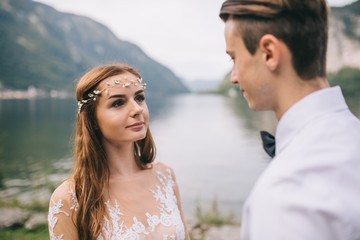 A wedding couple on the background lake and mountains in the fairy-tale town of Austria, Hallstatt.