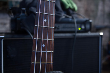 Fototapeta premium Fretboard of a bass guitar, on amp background.