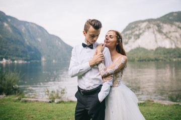 A wedding couple on the background lake and mountains in the fairy-tale town of Austria, Hallstatt.