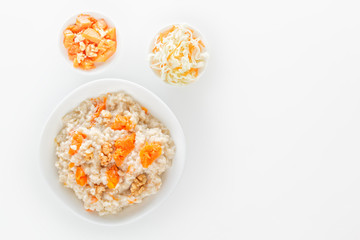 Fototapeta na wymiar Oatmeal with pumpkin and nuts, cabbage and carrot salad on a white background. View from above. Copy space.