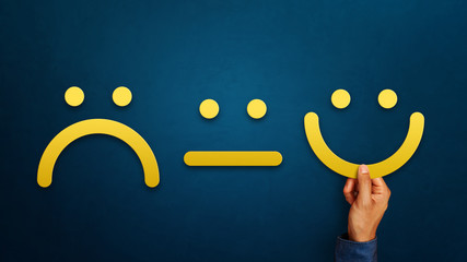 Hand of client show a feedback with smiley face sign. Service rating, satisfaction concept