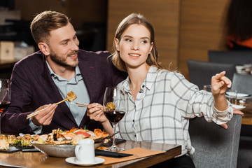 Attractive couple having dinner while woman pointing at something in restaurant