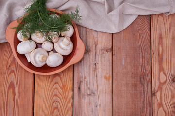 Champignon mushrooms, fresh greens in a ceramic plate. country style