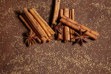 Cinnamon sticks and star anise on scattered brown sugar. The concept of baking, desserts, drinks, mulled wine