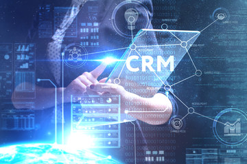 The concept of business, technology, the Internet and the network. A young entrepreneur working on a virtual screen of the future and sees the inscription: CRM