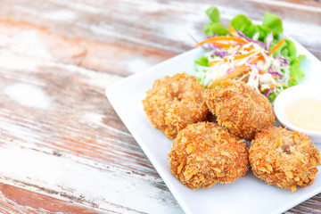 delicious fried shrimp, Thai seafood style, with sweet sauce and vegetable salad in white plate with copy space of wood table