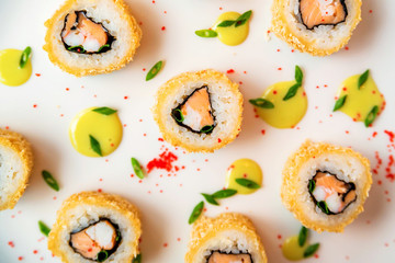 Sushi rolls scattered on white background top view