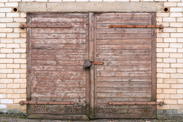 Wooden garage door on brick wall