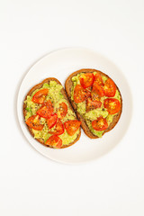 Avocado toast. Healthy toast with avocado mash and cherry tomatoes on a plate.