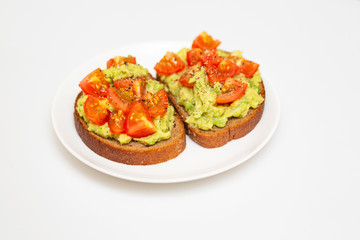Avocado toast. Healthy toast with avocado mash and cherry tomatoes on a plate.
