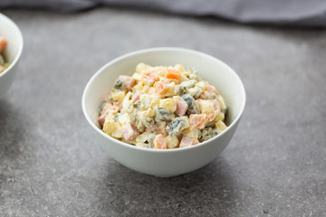 Russian salad in white bowl. National cuisine. Russian traditional salad Olivier for New Year party.