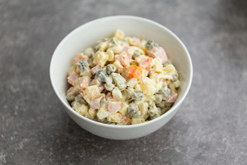 Russian salad in white bowl. National cuisine. Russian traditional salad Olivier for New Year party.