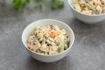 Russian salad in white bowl. National cuisine. Russian traditional salad Olivier for New Year party.