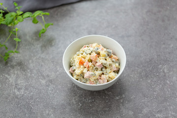 Russian salad in white bowl. National cuisine. Russian traditional salad Olivier for New Year party.