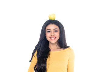 beautiful happy young african american woman with apple on head smiling at camera isolated on white