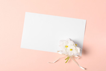Bouquet of violet flowers (viola) and empty greeting card on pink paper background. Valentine's day celebration concept. Top view. Flat lay. Mock-up