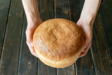 hands holding giving the fresh loaf of bread  f