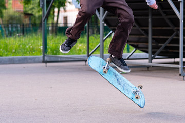 Skater boy performs a trick. Battered and scruffy skateboard.
