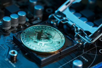 Golden Bitcoin Cryptocurrency on computer circuit board CPU. Macro shot.