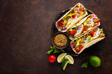 Mexican tacos with chicken meat, vegetables and fresh greens