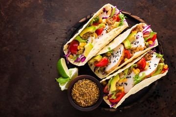 Mexican tacos with chicken meat, vegetables and fresh greens