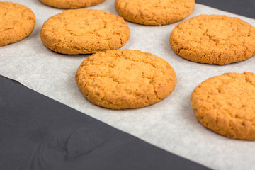 Homemade oatmeal cookies on parchment on black table. culinary background. Healthy Food Snack Concept. baking gingerbread