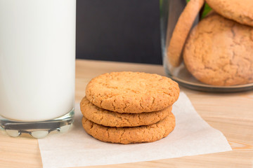Healthy Food Snack Concept. Milk and Stack of oatmeal cookies. Homemade gingerbread on natural wooden table.