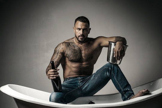 Champagne celebration. Handsome man with tattooed body on gray background.  Sexy night party - young lovers. Fashion mans legs in jeans. Stock Photo |  Adobe Stock