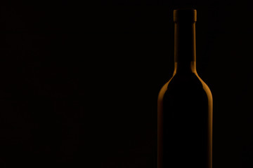 Silhouettes of bottles of wine in warm colors on a black background.