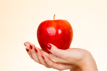 Woman hand holding delicious red apple
