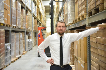 portrait of a successful businessman in a suit in the warehouse of a forwarding agency 