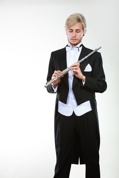 Male flutist wearing tailcoat holds flute