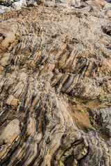 Brown stone background with vertical layers and patterns.