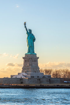 Statue of liberty vertical during sunset in New York City, NY, USA