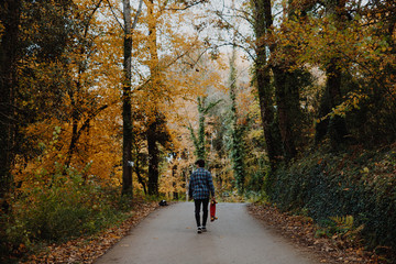 Obraz premium Man walking in the road in the autumn forest of Canada