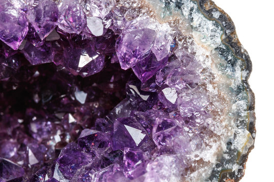Macro Mineral Stone Amethysts in the rock on a white background