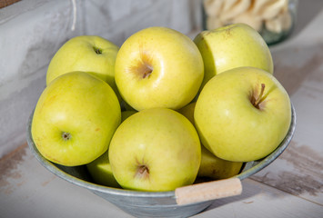 delicious golden apples in metal container