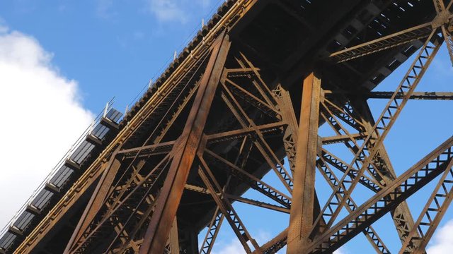 Low angle view of rusty steel trestle train bridge. Winter in Toronto, Canada.