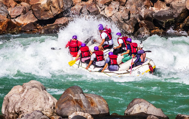 Young persons rafting on the river Ganges in Rishikesh, extreme and fun sport at tourist attraction - obrazy, fototapety, plakaty
